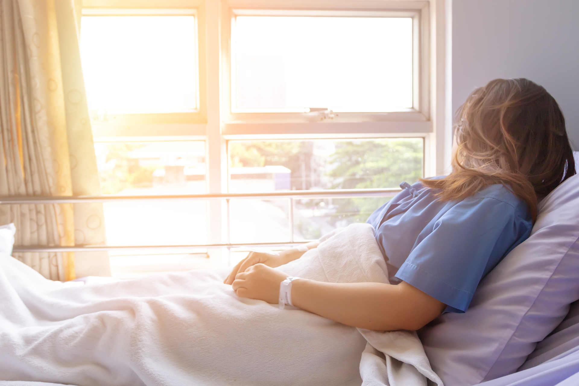 Woman in hospital bed looking out window