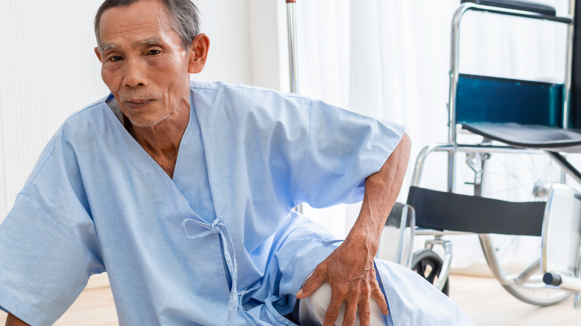 An older man on the floor after falling out of wheelchair.